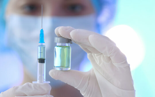 Doctor holding syringe and medicine for vaccination, closeup